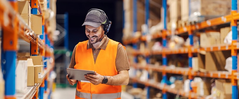 a man in a vest and headphones looking at a tablet