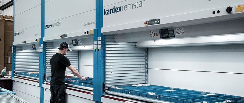 a man standing in front of a large automated storage and retrieval system